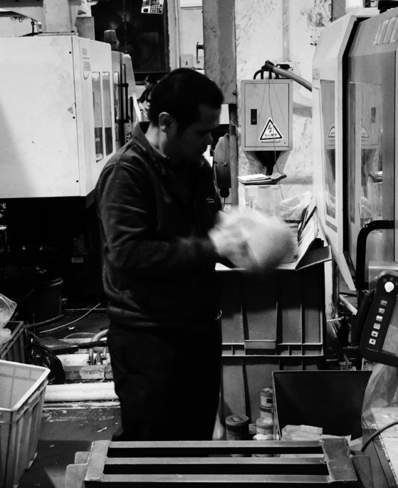 a-man-working-on-a-machine-in-a-factory.jpg a man working on a machine in a factory